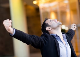 Successful businessman with arms up celebrating his victory